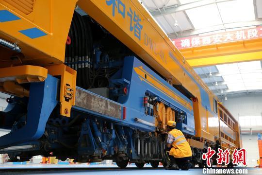圖為工人正在清理大型養(yǎng)路機械?！堖h 攝